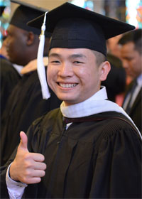 Hoang Tran gives a thumbs up at his graduation ceremony