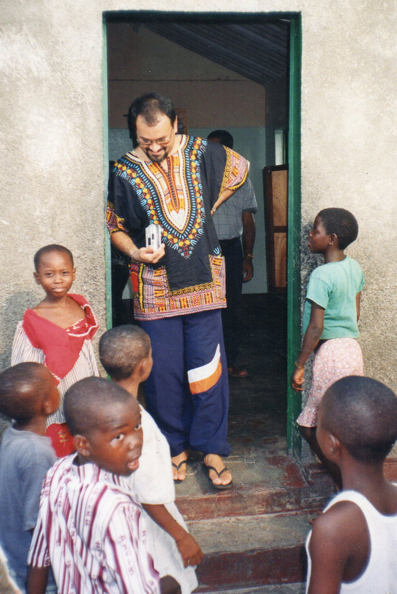Omir Olivera standing in a doorway speaking with children in Africa