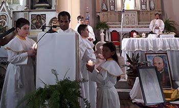 Fr. Kornelius Nika reading the Gospel in a Catholic Chuch