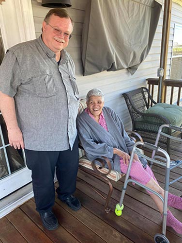 Fr. Gus Wall, SVD visits with an elderly woman at her home
