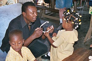 Fr. Pierre helps a young school girl with an audio headset