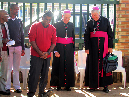 Fr Shiju regards a new pet cat with leaders of the Chicago Catholic Church