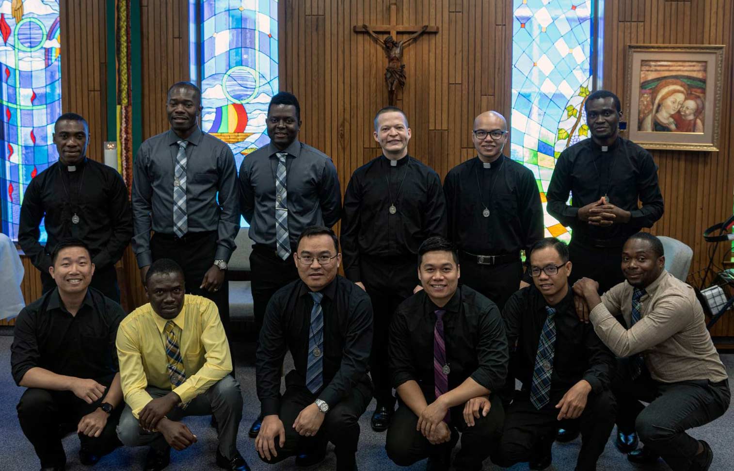 Six men stand in a line behind six men squatting in a formal group photo