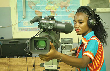A woman operates a television camera