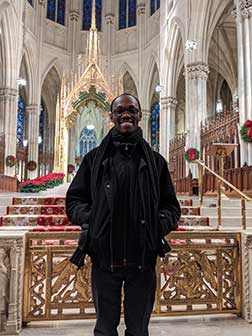 Frt. John Nkum stands in front of altar in a Catholic Church