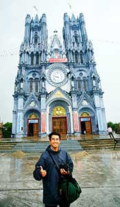 Frt Martin Vu, SVD stands in front of a Vietnamese Catholic Church