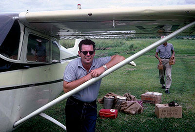 Man standing next to a small single-engine plane