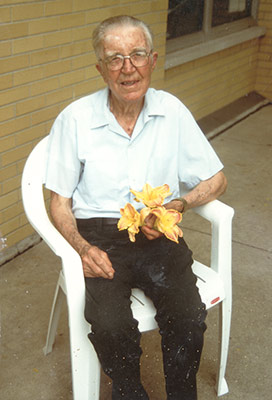 Elderly man holding three yellow lily flowers