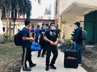 young people wearing protective masks while moving out of dorm