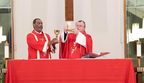 Fr. Gus Wall, SVD, raises the host during consecration