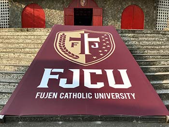 Fu Jen University banner unrolled on steps to a building