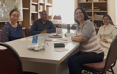 Group of staff members sitting at a table smiling for camera