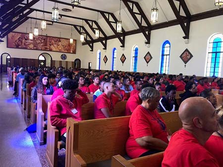 A church full of people wearing matching red t-shirts