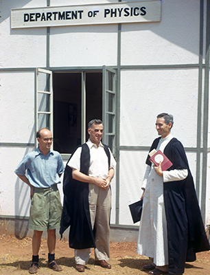 Three men standing outside Department of Physics building