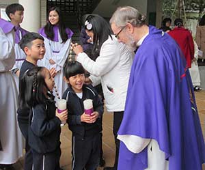 Fr. Dan Bauer shares a laugh with children after Mass