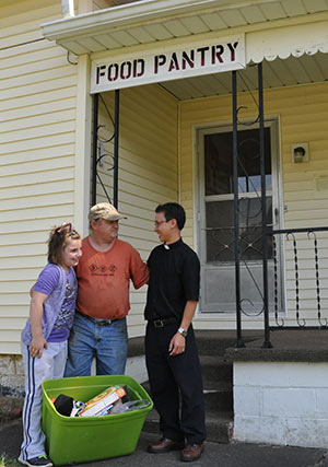 Fr. Thien Duc Nguyen, SVD, meets with parishioners at the food pantry.