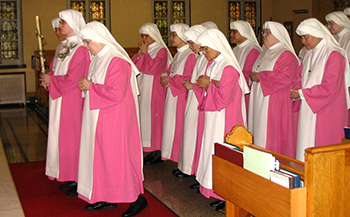 Religious women in pink habits in a church
